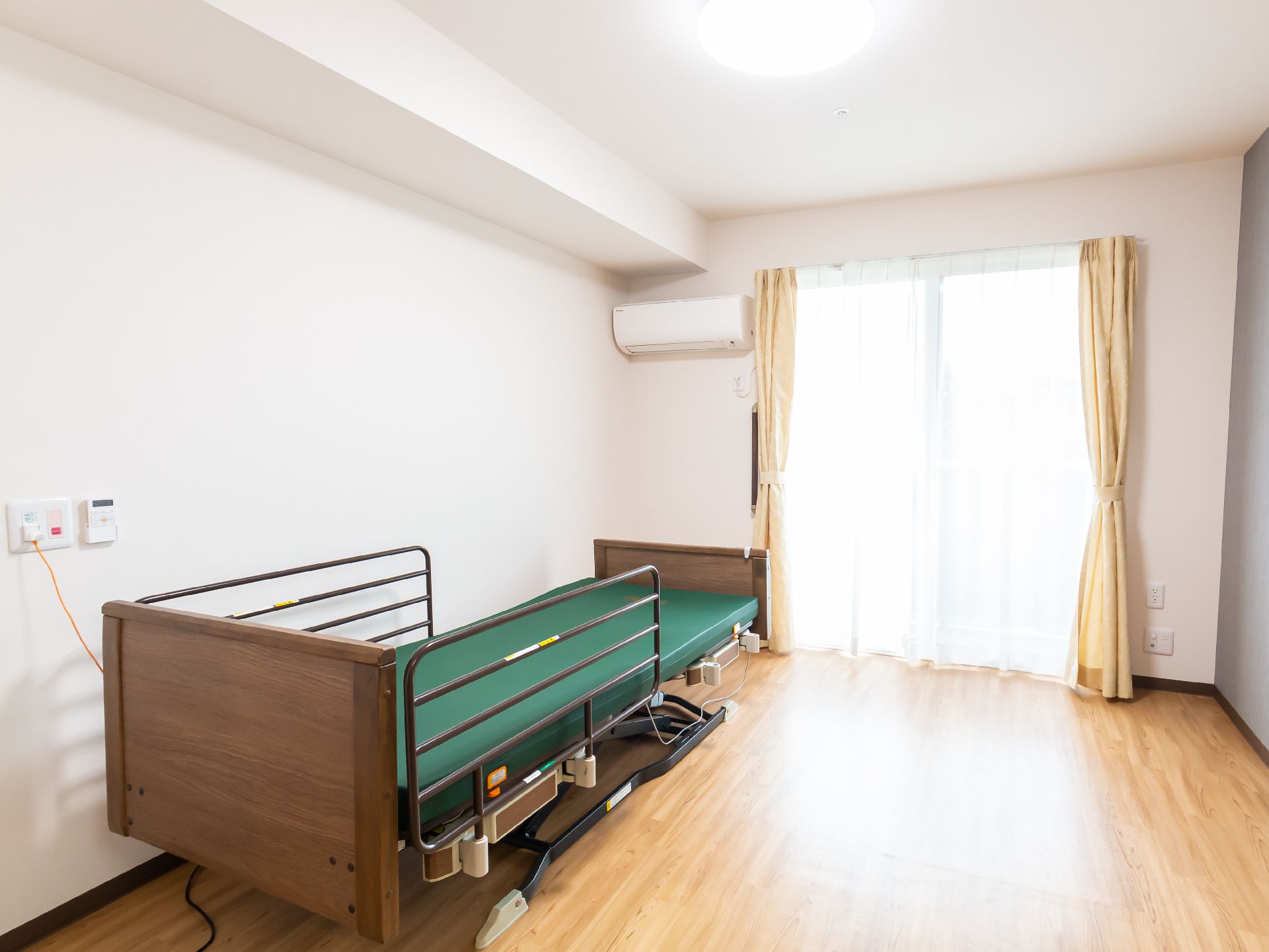 壁沿いに大きなベッドと窓がある白い壁紙の部屋