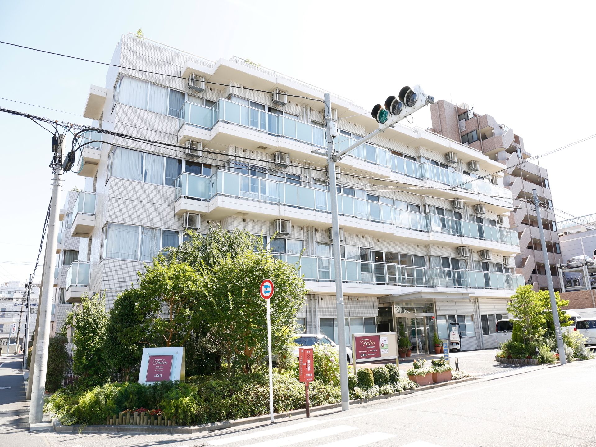 施設は角地に立っており、目の前には信号がついている。樹木を背景に看板がでており、4階建のマンションのような作りになっている。