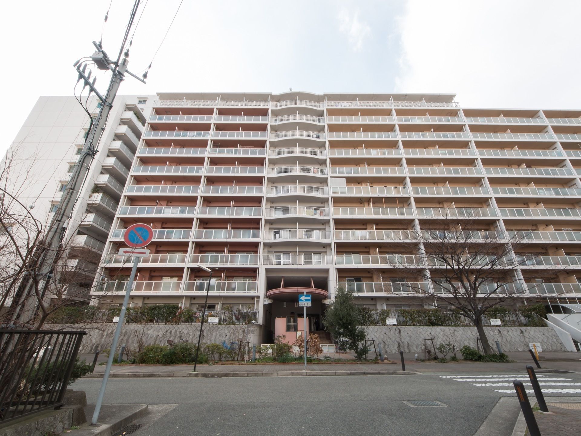 11階建ての高層のマンションになっている。建物は道路に面しており、正面には横断歩道が設置されている。