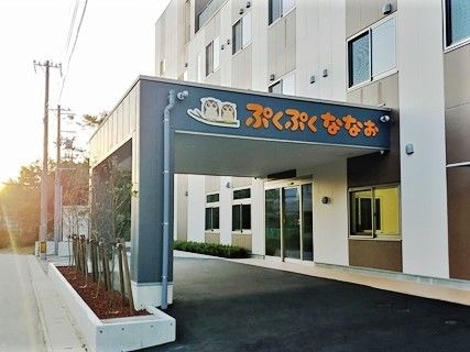 「ぷくぷくななお」という看板が掲げられている施設入りぶちの雨除け用のひさしと外観