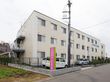 道路沿いに立地しているベージュ色の３階建ての建物