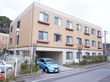 茶色が基調の外壁となっている３階建ての建物である。駐車場があり車での来訪も便利である。建物の周りに木々が植えられている。