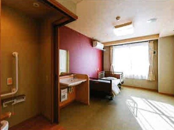 トイレや洗面所が付いたシンプルな居室は介護対応型のデザインで壁には緊急通報装置がある。