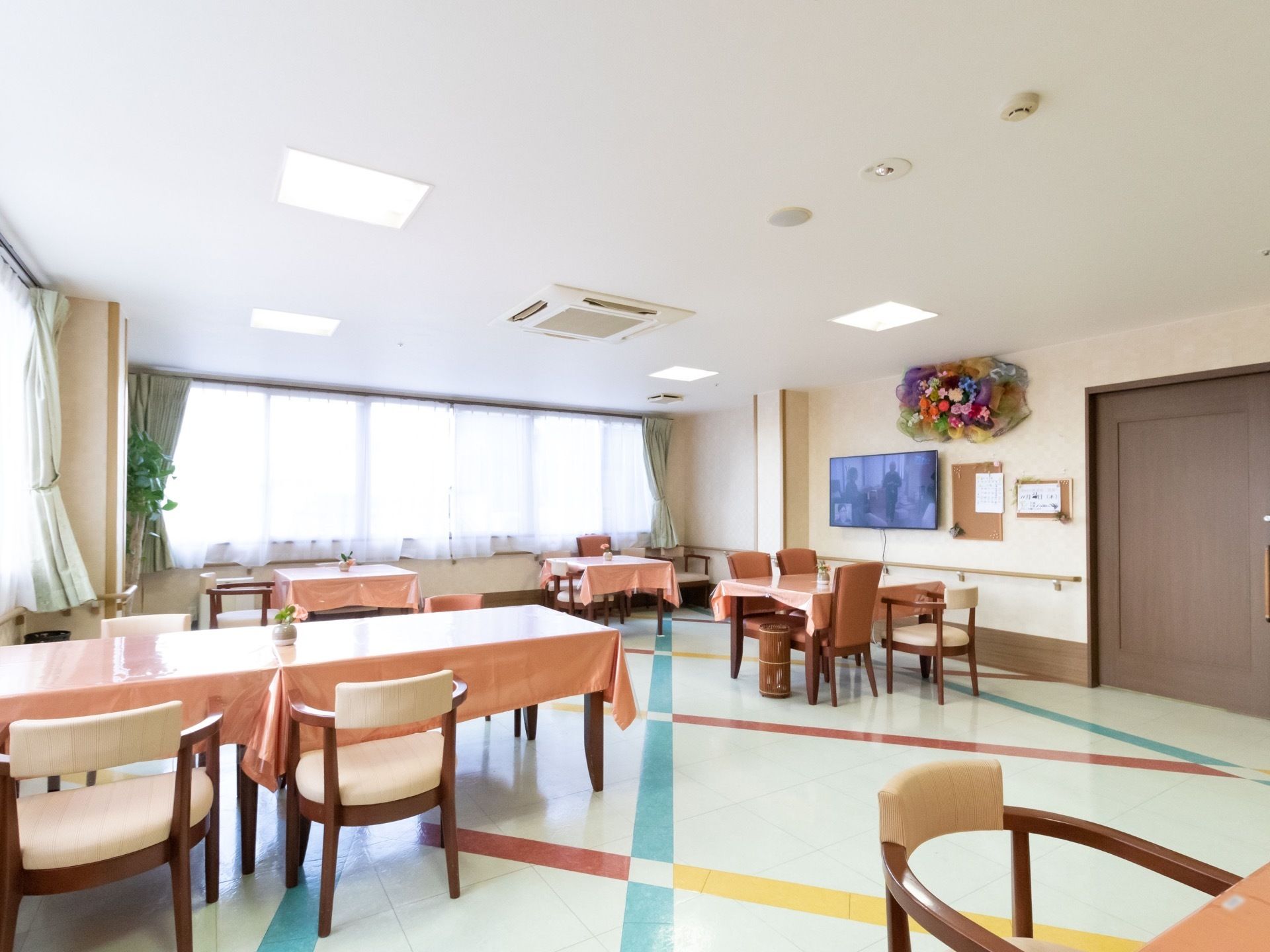 食堂は窓が2方向にあり、日当たりが良く親しみやすい雰囲気。壁にはテレビが設置され、鑑賞しながら食事ができる。