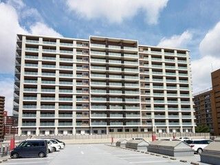 車が数台停まっている駐車場とマンションのような建物