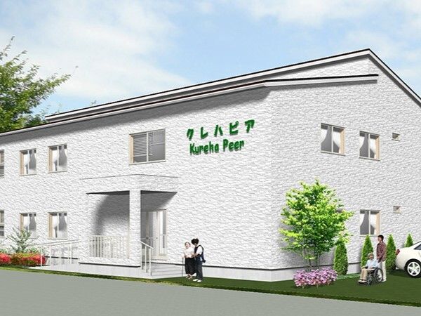 白を基調とした２階建ての建物は日当たり良好で、玄関先には手すり付きのスロープや階段がある。