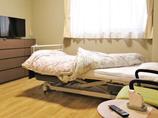 クローゼットやタンス、寝具付きのベッドなどが置かれた居室には車いす対応の広いトイレがあり、テレビも設置されている。