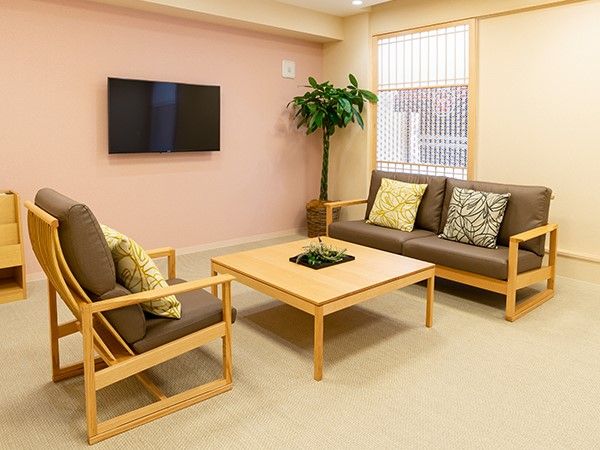 和風のソファが1脚と和風の椅子が1脚、和式テーブル1脚ある部屋。