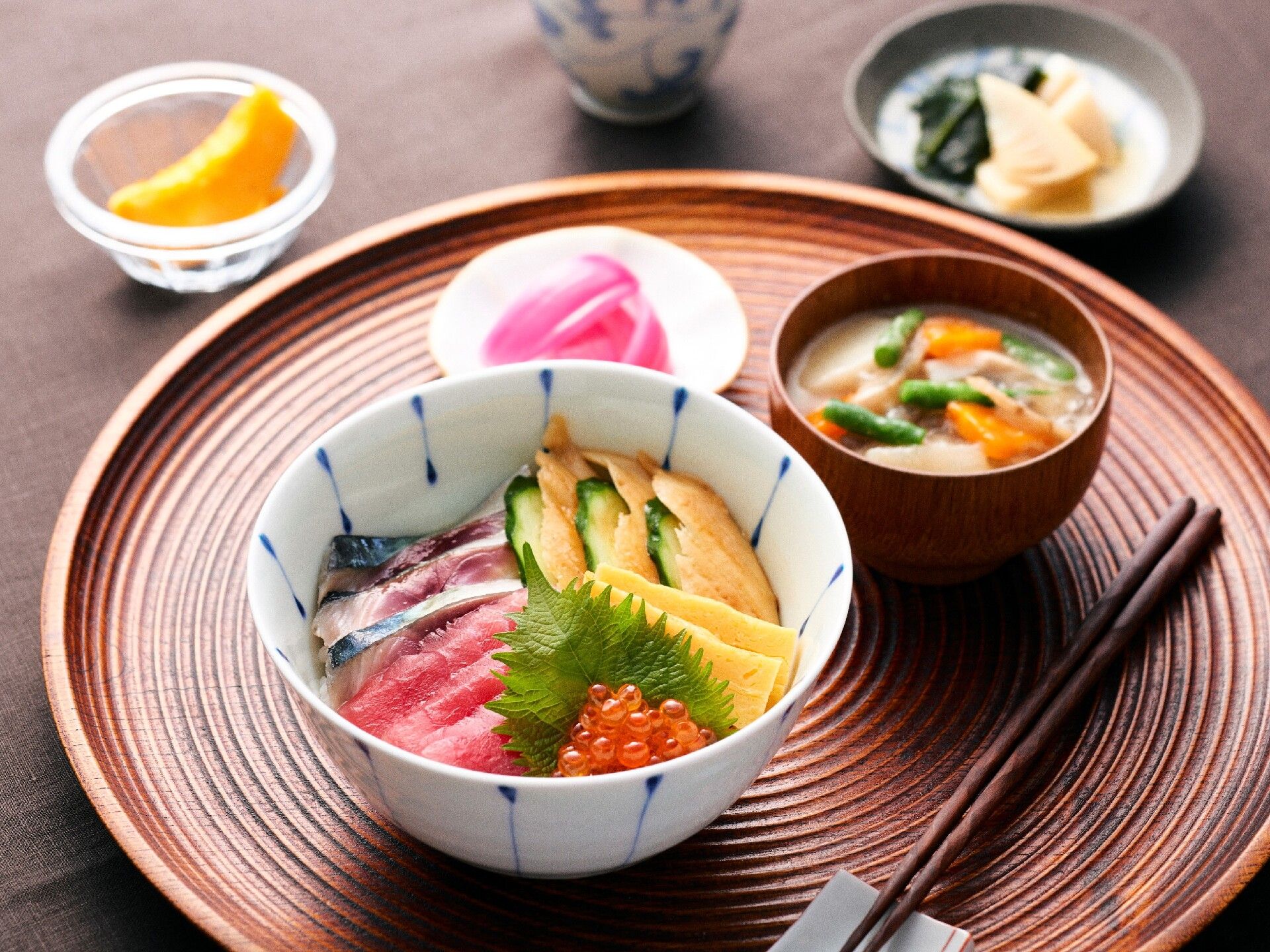 食事。丸盆に載せられた刺し身丼と味噌汁。漬物もある