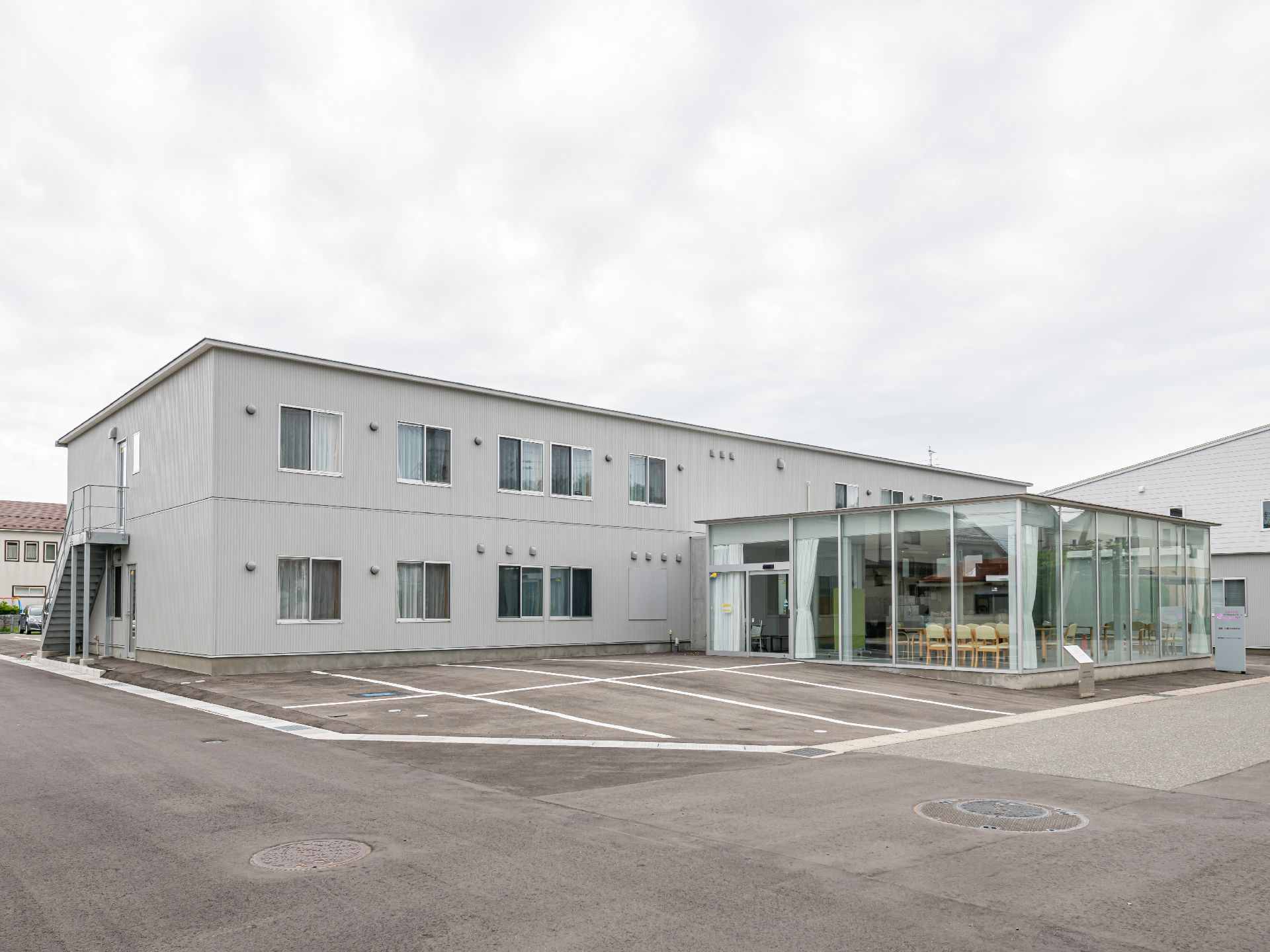 2階建てで、白の落ち着いた色合いが特徴の施設の外観
