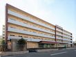 5階建ての建物は横に長く、2階以上の階にはベランダが付き、玄関には車寄せがあり、駐車スペースも確保されている。