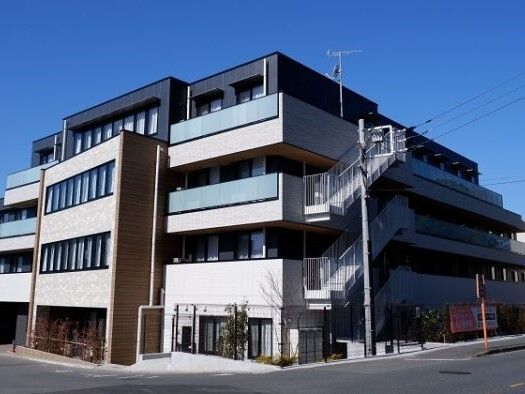 屋外階段が設置された建物の各フロアにベランダが付いている。4階建ての建物は日当たりのいい場所に建っている。