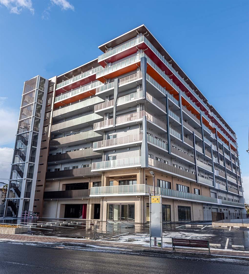 青空には太陽がさんさんと輝いていて、白く大きなマンションのような建物を照らしている。各フロアにベランダがある
