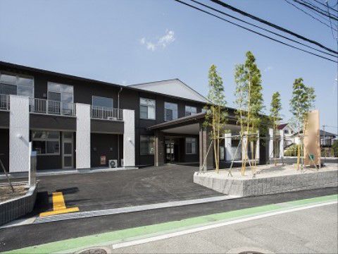 黒と白に塗り分けられたおしゃれな外観は、施設内の窓の多さも見て取れる。施設周囲は植栽を多く植えている。