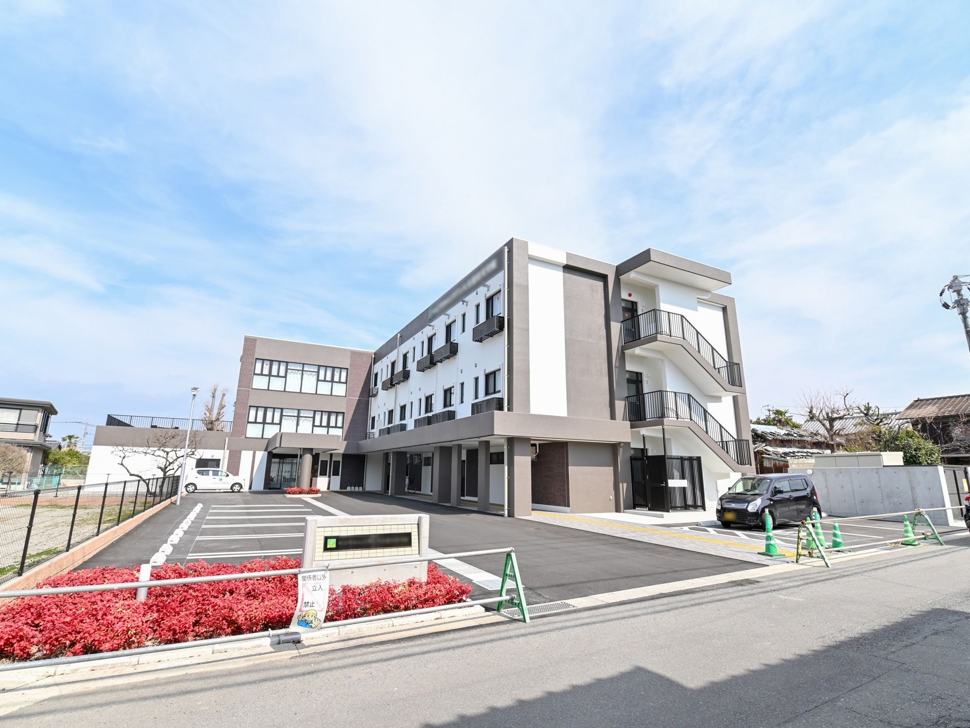 シックな色合いの施設外観である。隣に平置きの広い駐車場があり、建物から近い場所に車椅子用駐車場も完備している。
