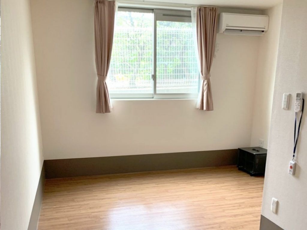 エアコンが付いたフローリングの部屋にはペンダント式の緊急通報装置も設置されている。