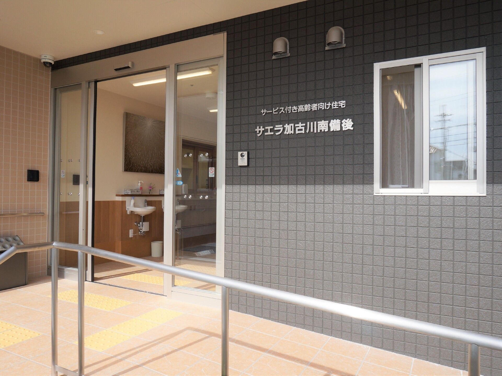 車いすの高齢者と同じ目線になって話しているスタッフとの2ショット