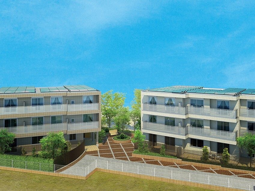 草木が植えられた広い敷地内には3階建ての建物が二棟建っている。敷地の周りにはフェンスがある。