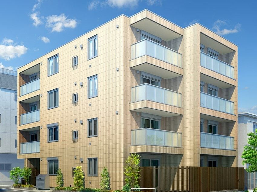 4階建ての建物ベージュ系で各フロアにベランダがある。周りには草木が植えられている。