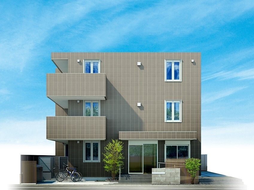 ブラウン系の3階建ての建物の周りには草木が植えられ、建物の前には一台の自転車が止められている。