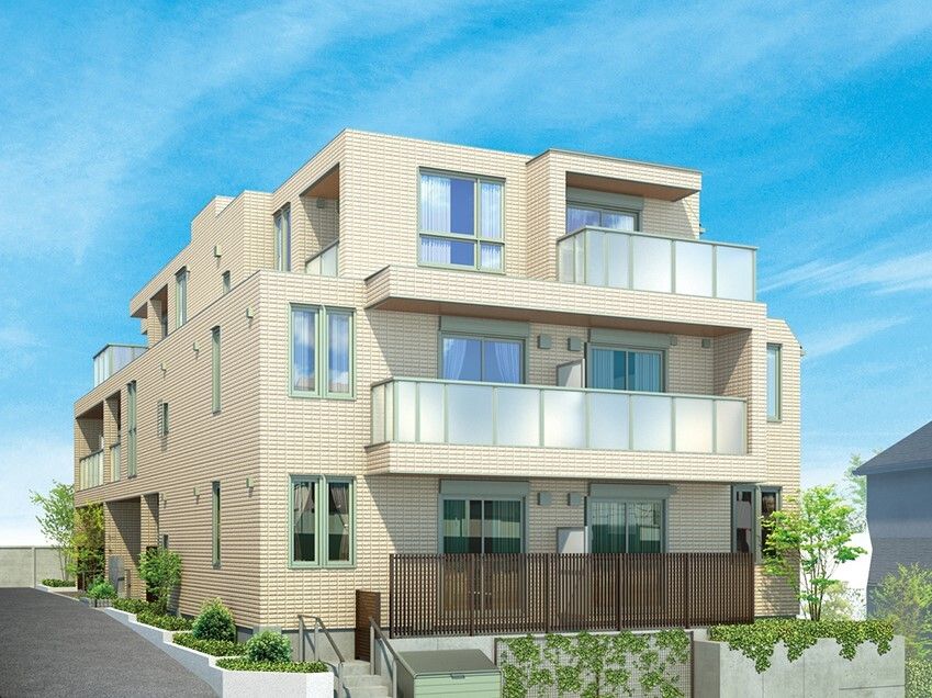 ベージュ系の3階建ての建物の周りには草木や花が植えられている。日当たりのいい場所に建っている。