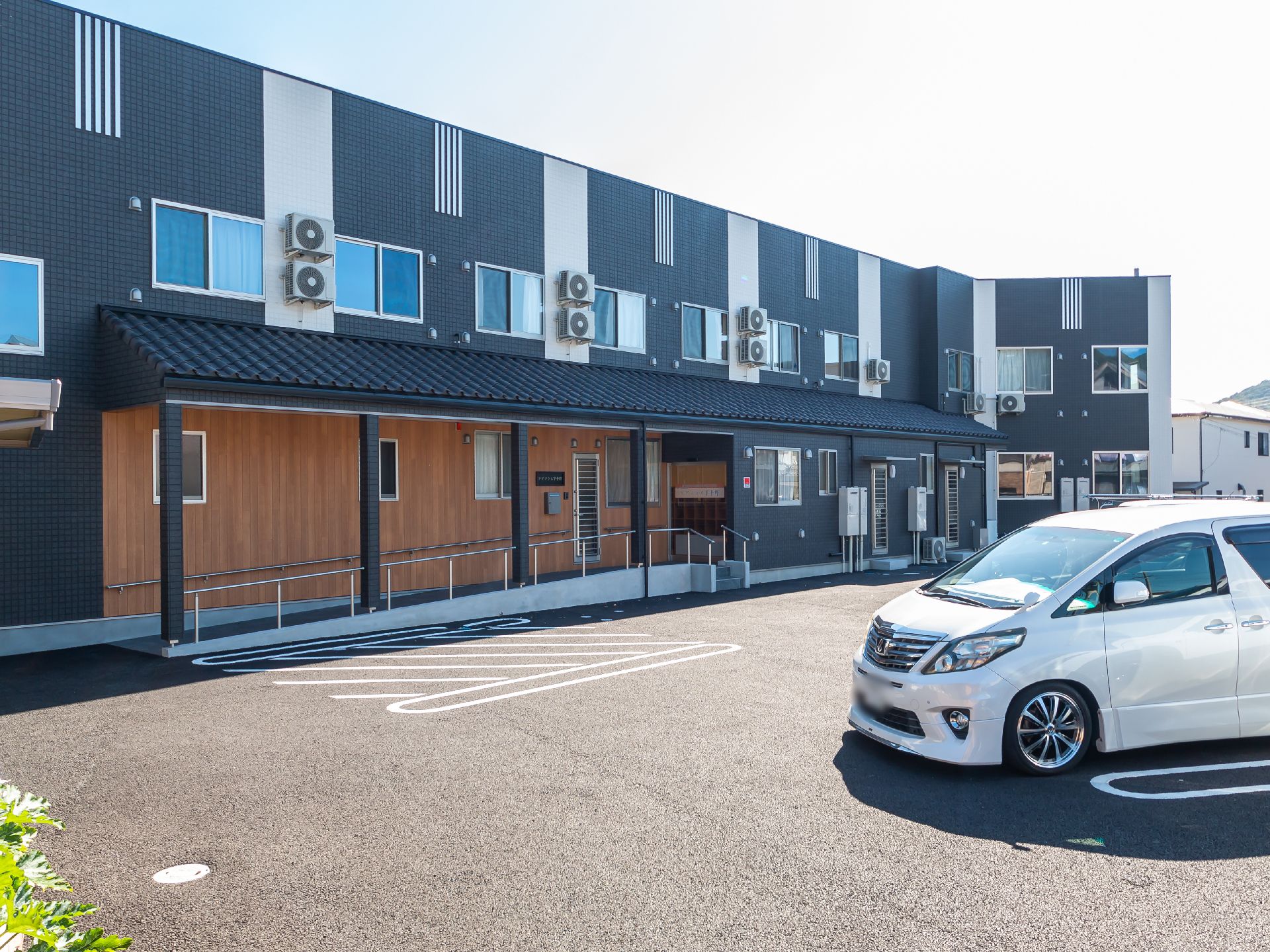 ２階建てで、青の落ち着いた色合いの施設の外観