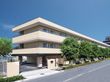 ３階建ての建物は日当たりのいい場所に建っていて、建物の周りには草木が植えられ、門もある。