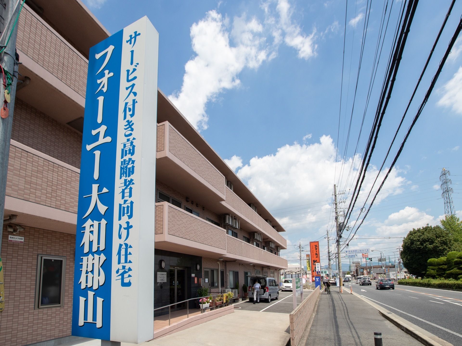 ３階建てのマンションタイプの施設である。大きな看板が分かりやすく取りつけられている。入口は緩やかなスロープである。