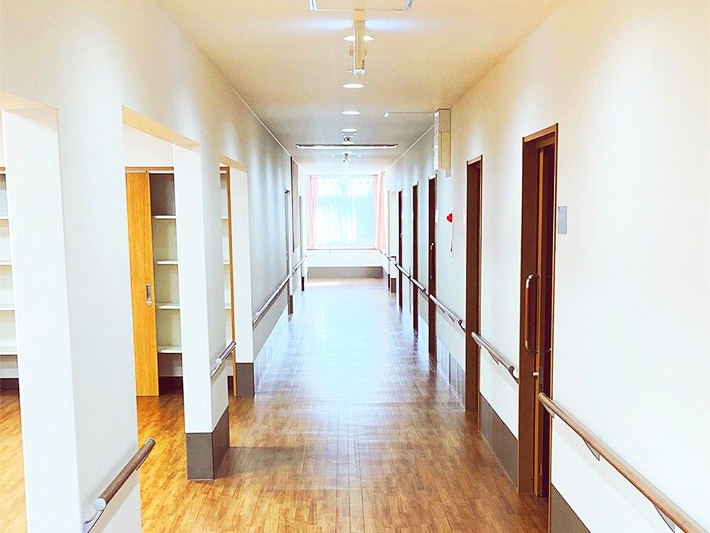 幅の広いまっすぐな廊下には手すりが付き、突き当りには窓があり、防災設備も付いている。