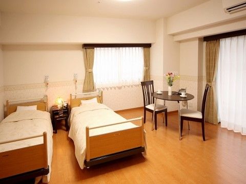 丸テーブルと椅子や、ベッドが設置された居室