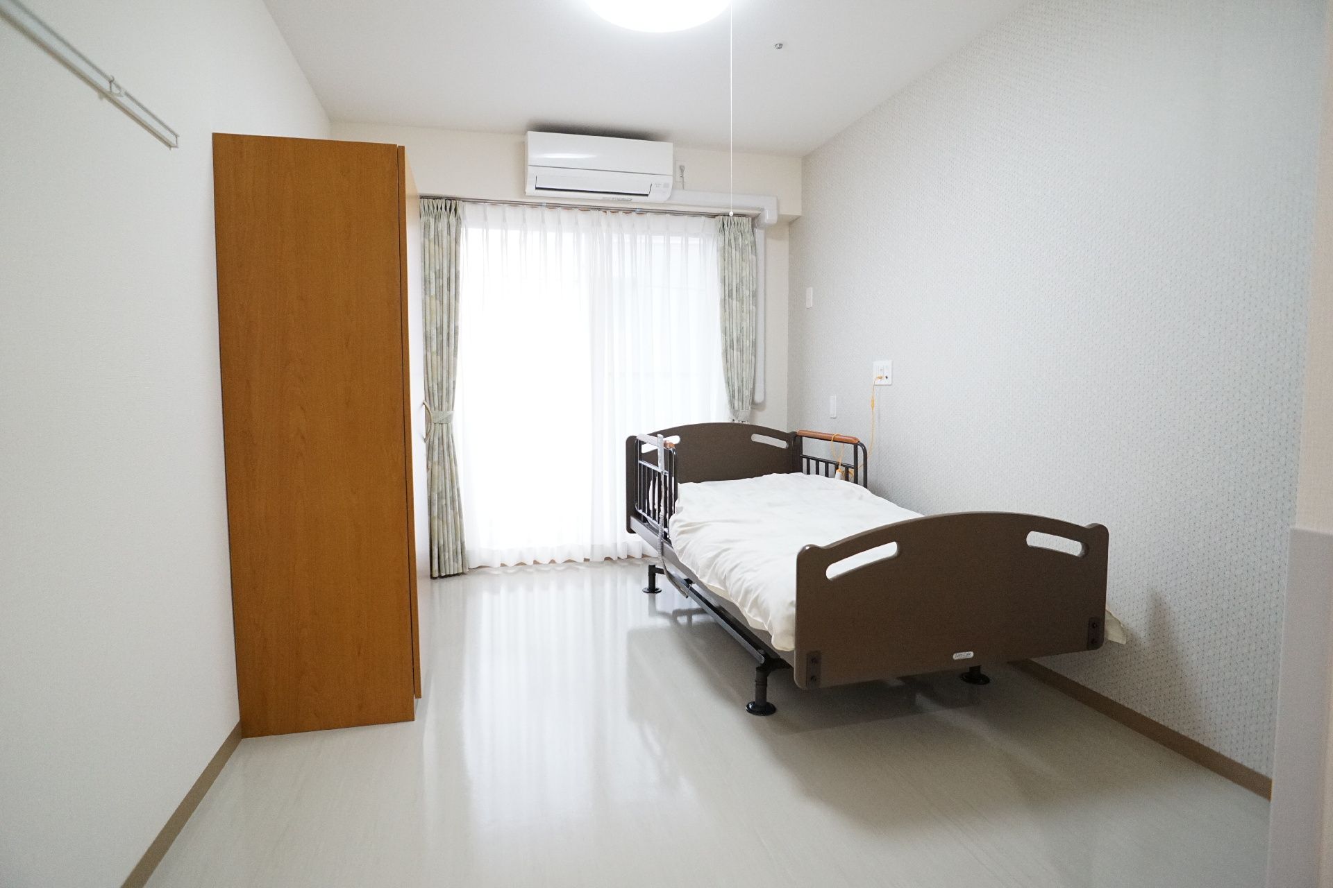 日差しが差し込み、介護ベッドや家具に日差しが当たっている居室
