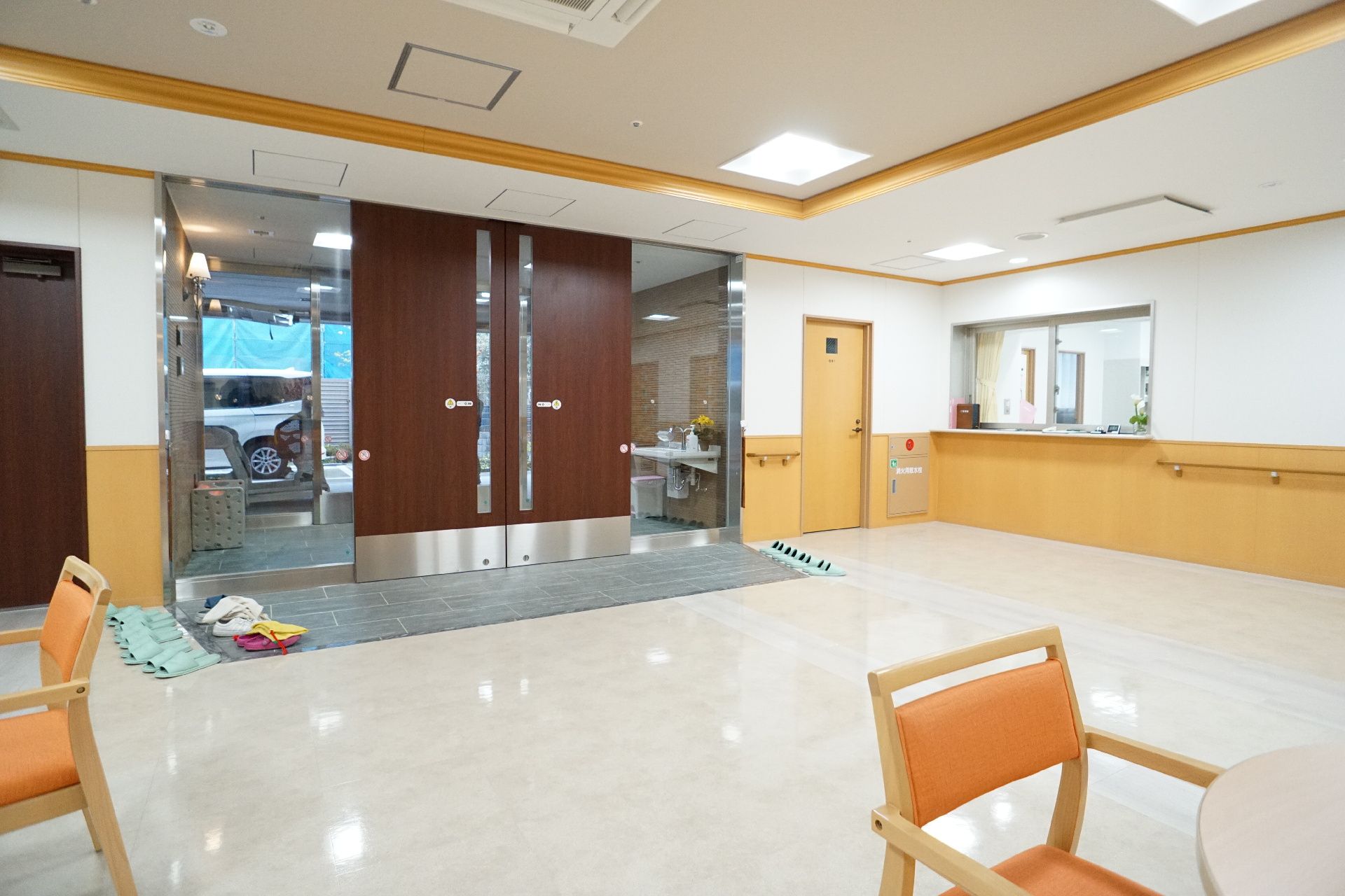 自動ドアが設置され、休憩用の椅子が置かれている玄関