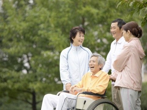 車いすに乗っている男性と寄り添う介護スタッフ