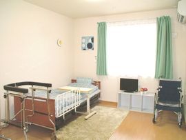 車椅子のご入居者様とスタッフ