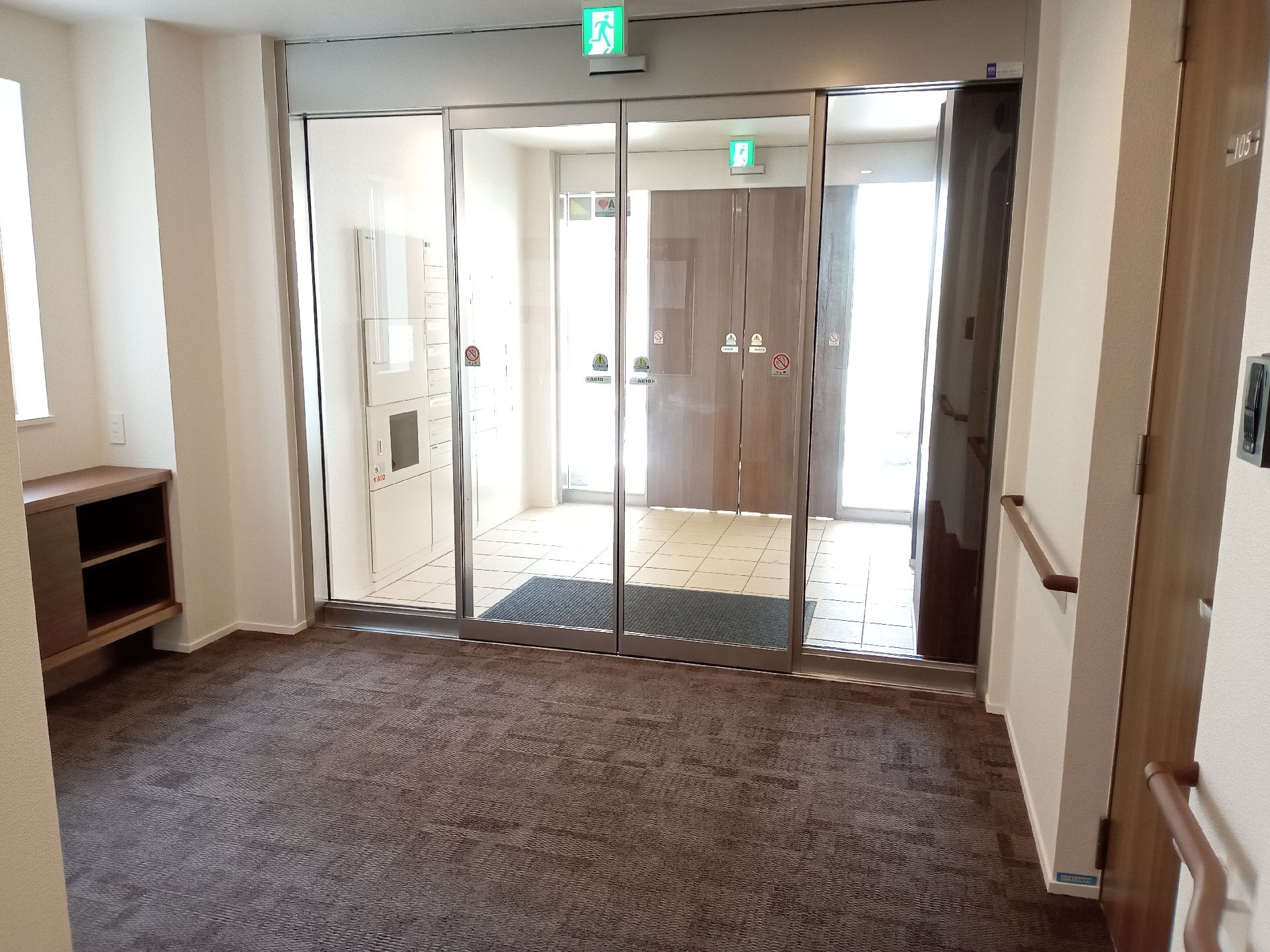 風除室が設置されているエントランスにはマットが敷かれ、自動ドアが設置されている。