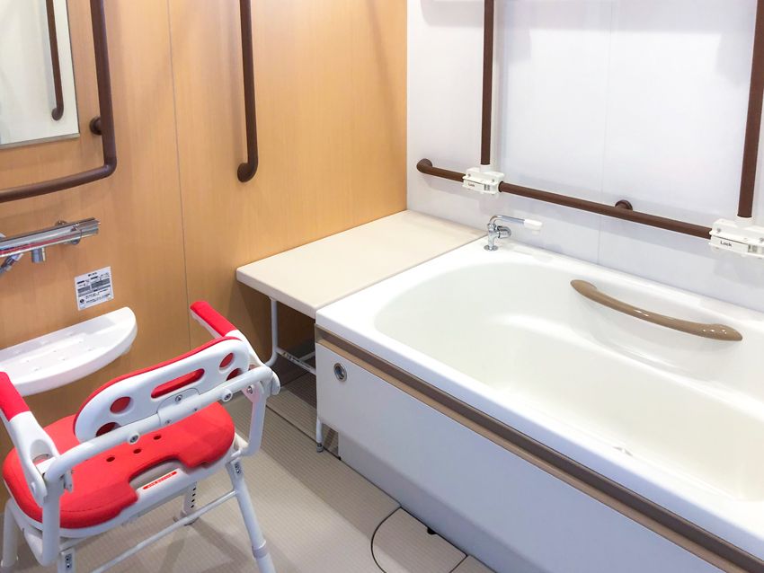 可動式の手すりが付いた浴室には一人用の浴槽が設置され、シャワーやシャワーチェアもある。