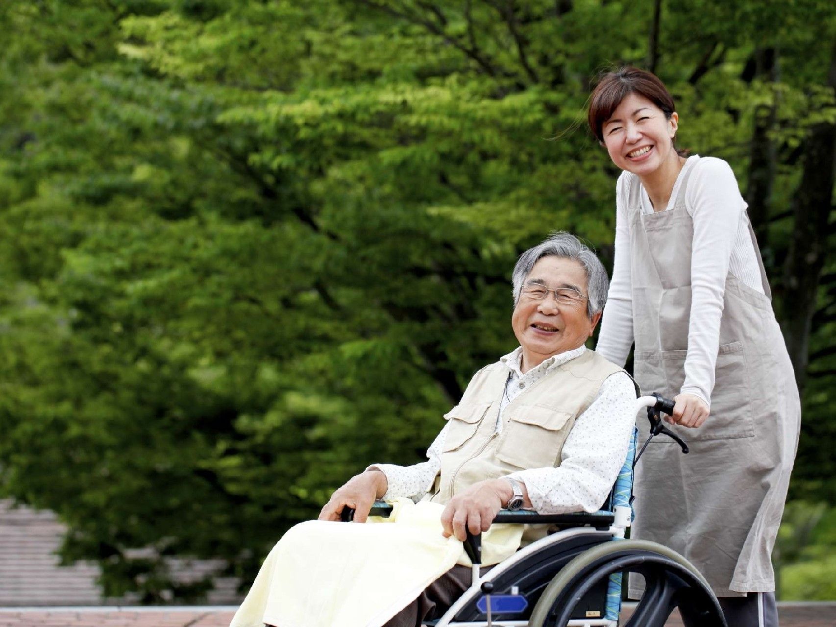車いすに乗った男性と車いすを押す女性