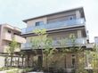 敷地内に複数の木々がある3階建てグループホーム