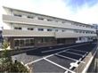 横方向に大きい3階建ての施設がある。施設のそばには駐車場があり、車をご利用の方でも安心である。玄関のそばまで車で向かうことができる。