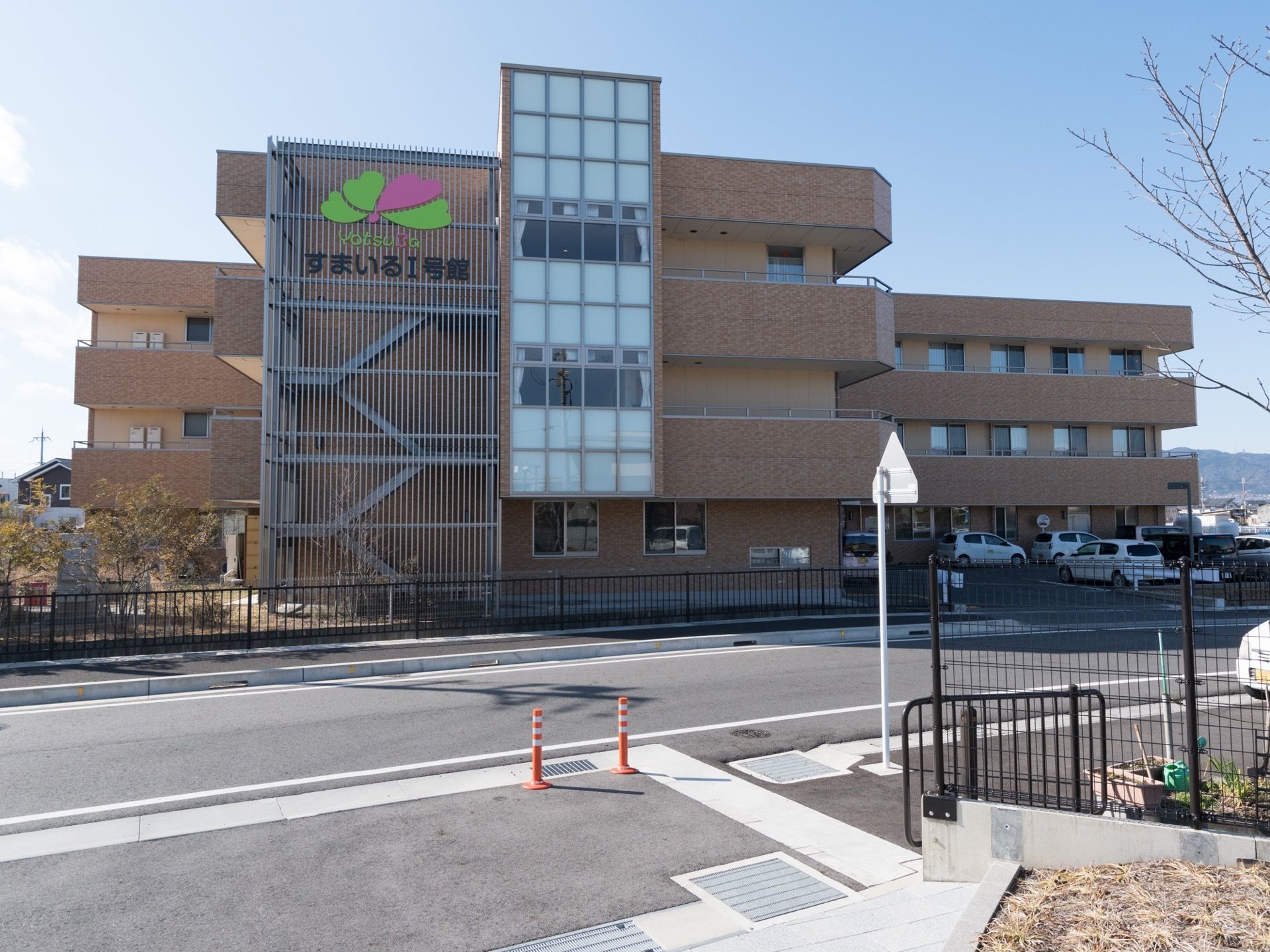 建物の２・３階部分のベランダ壁には手すりが取り付けられている。外部階段は、完全にフェンスで覆われている。